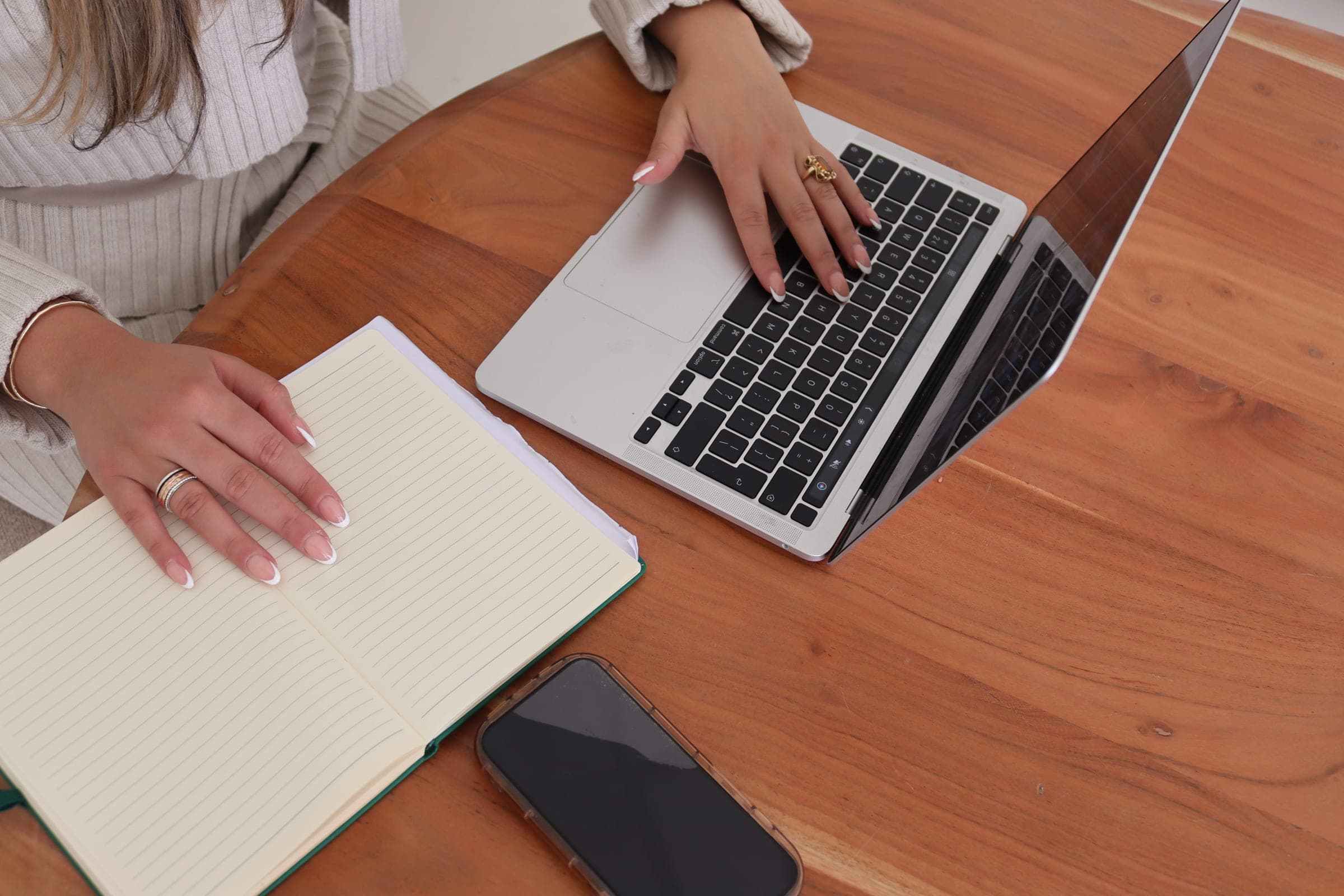 Laptop, notebook and phone on a wooden table during an account review